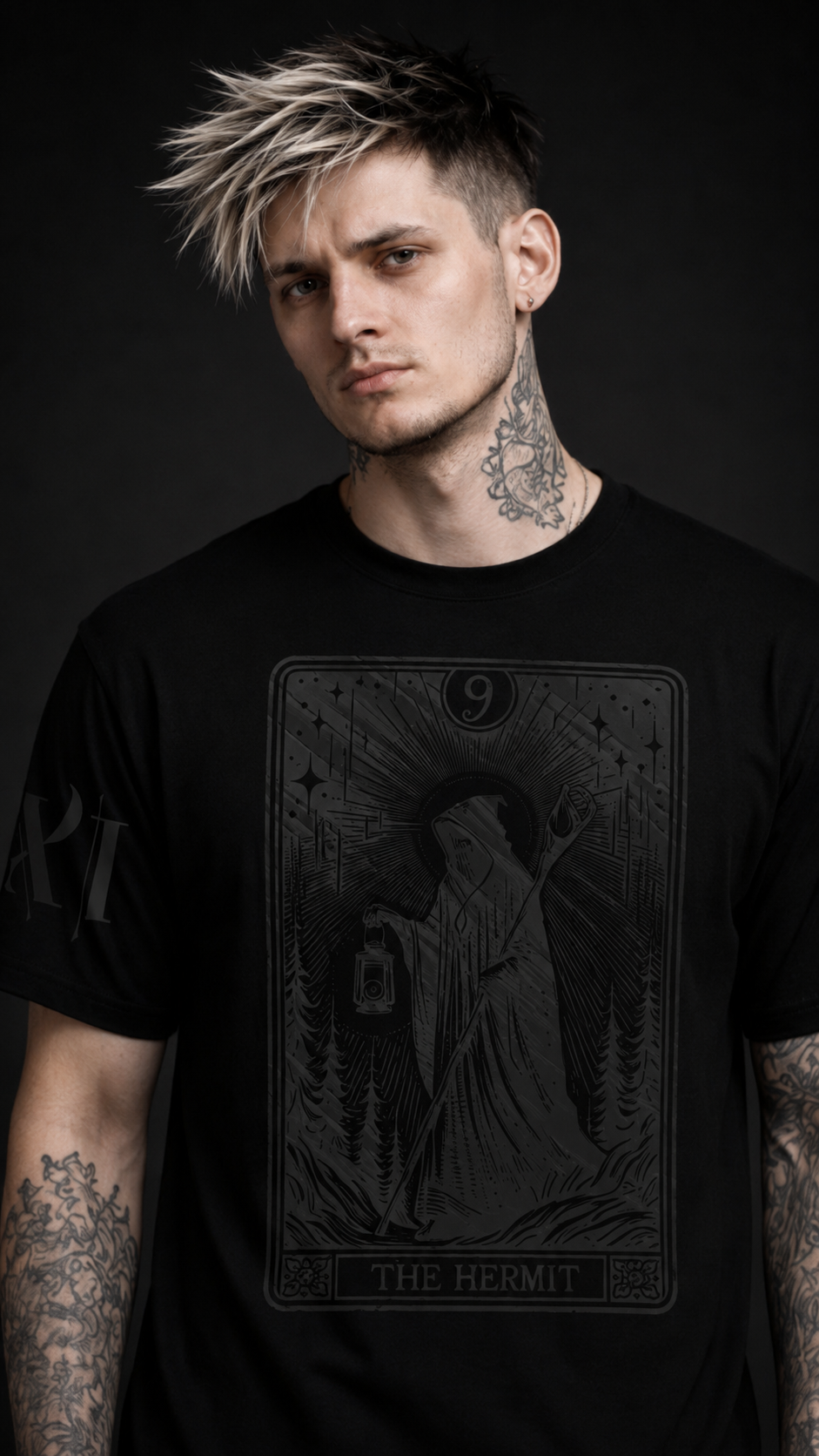 Man wearing a black t-shirt with a tarot card design on a dark background